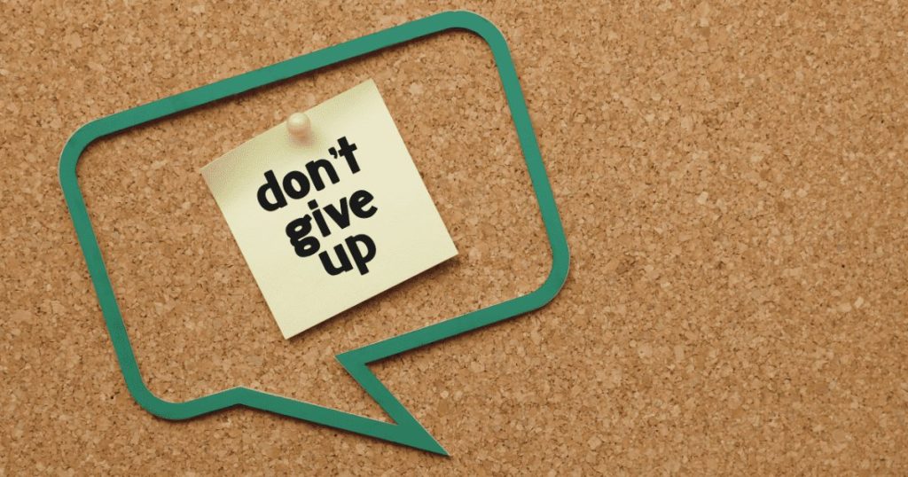 コルクボード上に吹き出しとdon''t give upと書かれた付箋