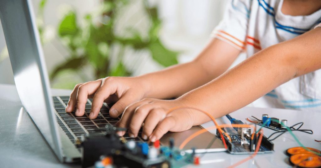 ロボットのプログラムをしている男の子の手元
