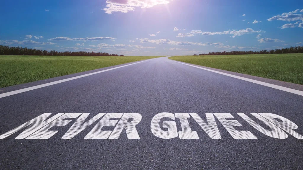 道路にNEVER GIVEUPと書かれている画像