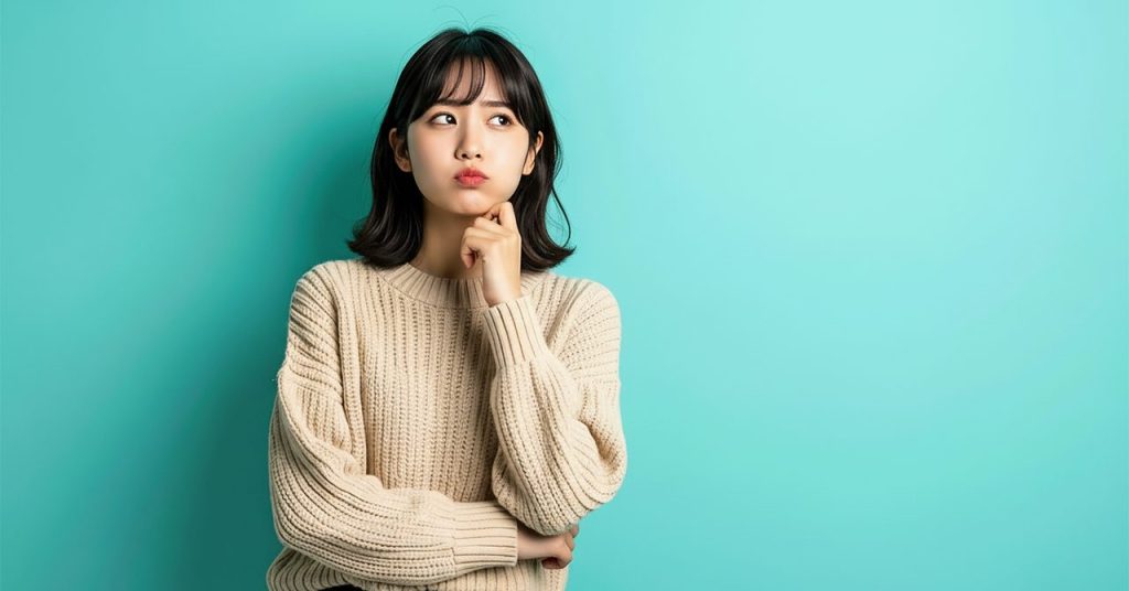 迷い、疑いの表情を浮かべる女性のビジュアル。