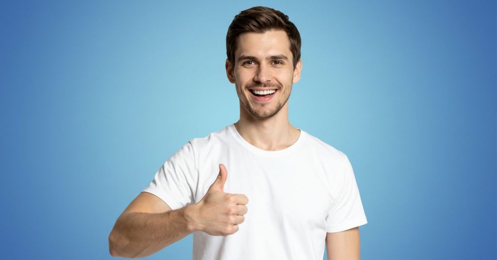 笑顔でグッドポーズをする男性。ポジティブイメージのビジュアル。