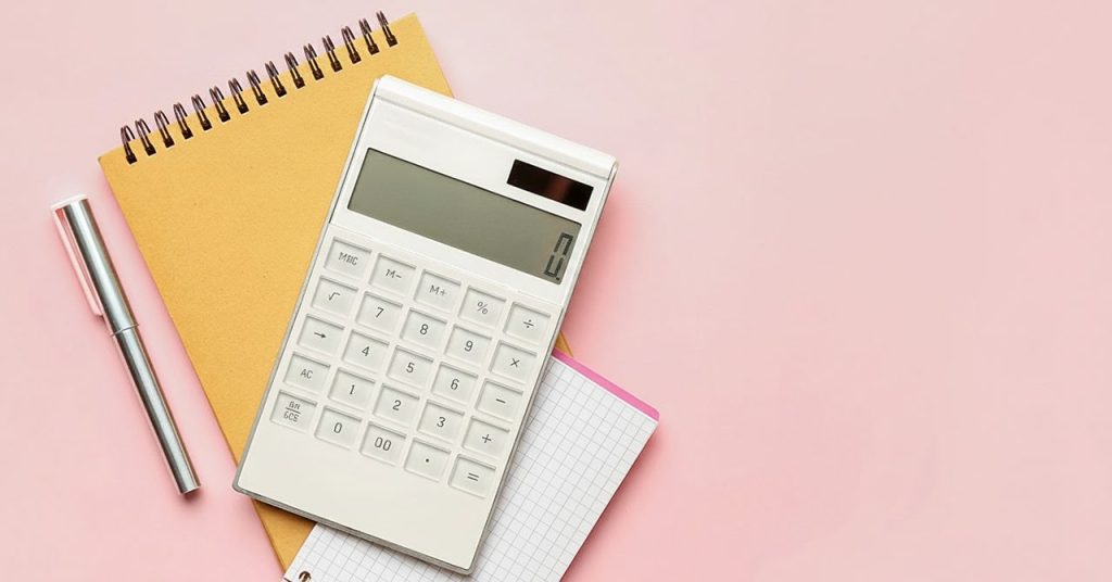 電卓、ノート、ペンの画像。お金の計算をイメージしたビジュアル。